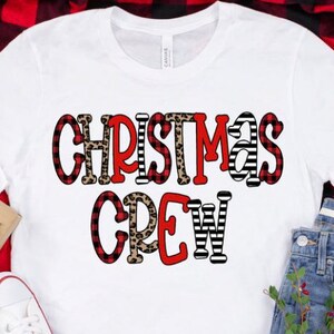 May include: White t-shirt with the text "Christmas Crew" in red, black, and white buffalo plaid, leopard print, and stripes.