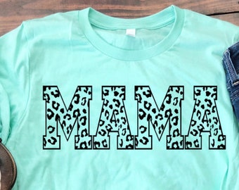 May include: A turquoise t-shirt with the word "MAMA" printed in black outlined letters. The letters are filled with a black and white leopard print pattern.