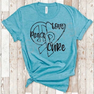 May include: A turquoise blue t-shirt with a black graphic design of a peace sign, a heart, and a ribbon. The text "Peace Love Cure" is written on the graphic.