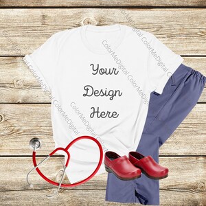 May include: White t-shirt with the text "Your Design Here" on a wooden background. A stethoscope, scrubs, and red clogs are also pictured.