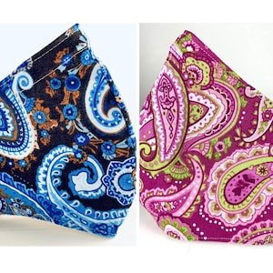 Pode incluir: Duas máscaras faciais com padrão paisley, uma em azul e marrom, a outra em rosa e verde.