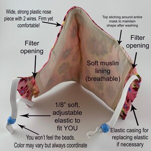 May include: A pink and white floral fabric face mask with a soft muslin lining, adjustable elastic ear loops, and a filter pocket. The mask has a wide, strong plastic nose piece with two wires for a comfortable fit.