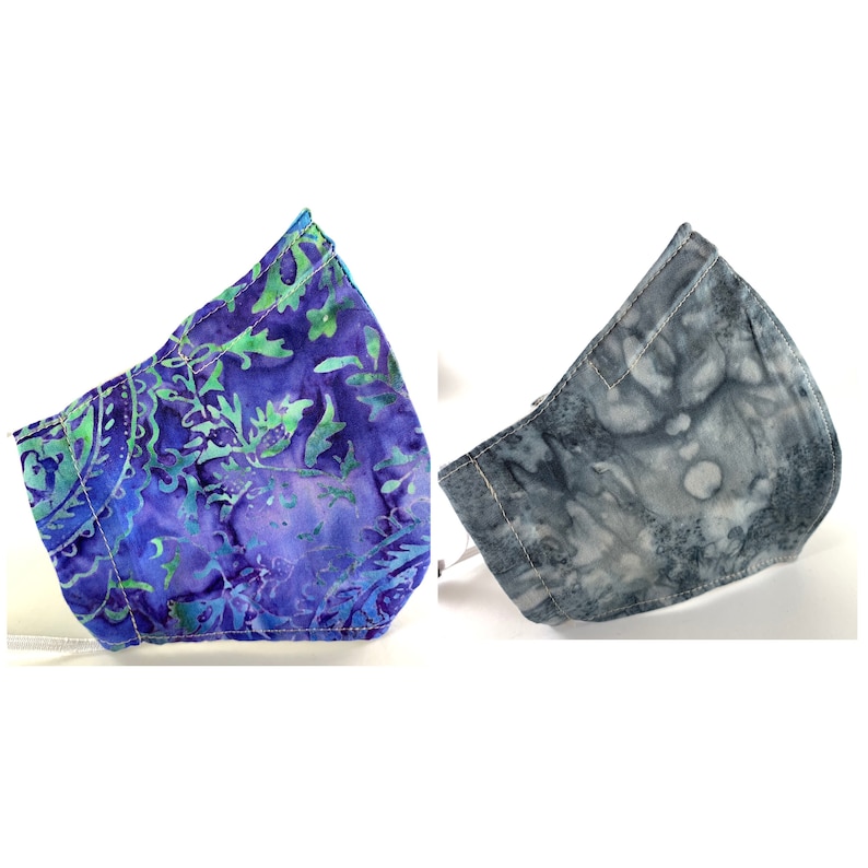 May include: Two fabric face masks, one with a blue and green paisley pattern and one with a gray and white tie-dye pattern.