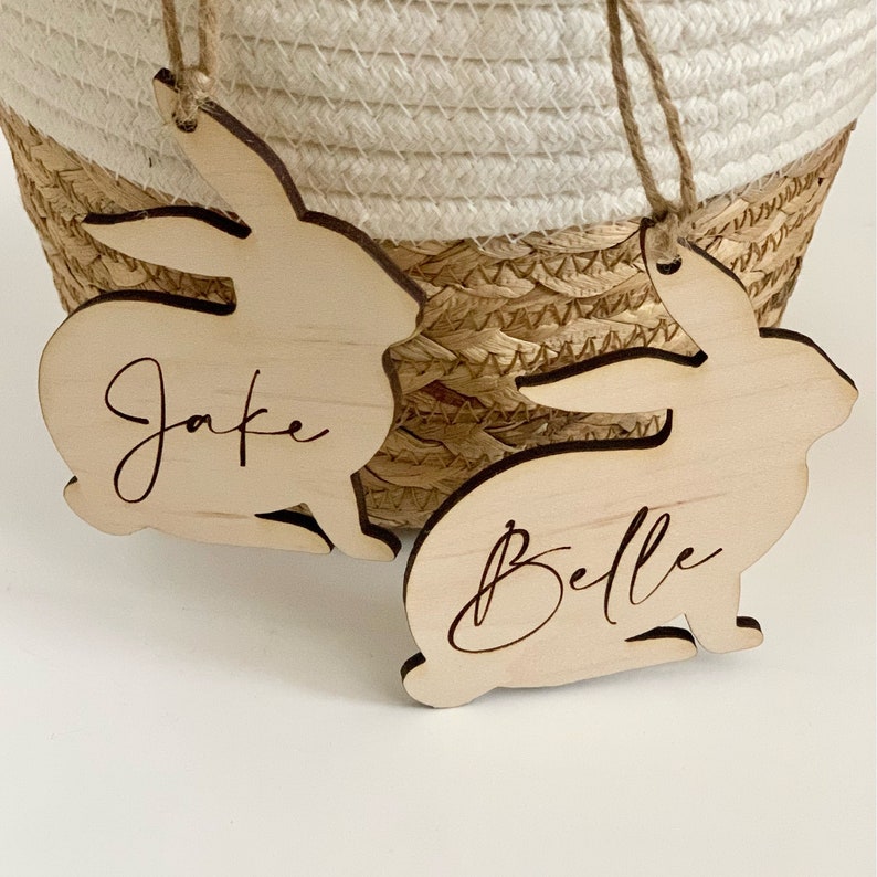 May include: Two wooden bunny shaped ornaments with the names "Jake" and "Belle" engraved on them.