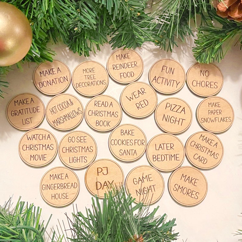 Puede incluir: Un conjunto de 18 fichas de actividades navide&ntilde;as de madera con diversas actividades festivas escritas en ellas, como "Hacer una donaci&oacute;n", "Ver una pel&iacute;cula navide&ntilde;a", "Hacer una casa de jengibre", "Ir a ver las luces navide&ntilde;as", "Leer un libro navide&ntilde;o", "Hornear galletas para Santa", "Vestir de rojo", "Actividad divertida", "Noche de pizza", "Hacer copos de nieve de papel", "Hacer una tarjeta navide&ntilde;a", "Hacer s'mores", "Sin tareas", "Chocolate caliente y malvaviscos", "Noche de juegos", "Acostarse tarde", "D&iacute;a de pijama", "M&aacute;s decoraciones para el &aacute;rbol", "Hacer comida para renos", y "Hacer una lista de gratitud".