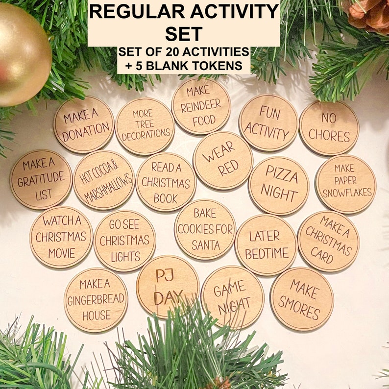 Puede incluir: Un conjunto de 25 fichas de actividades navide&ntilde;as de madera con diversas actividades escritas en ellas, que incluyen "Hacer una donaci&oacute;n", "Ver una pel&iacute;cula navide&ntilde;a", "Hacer una casa de jengibre", "Leer un libro navide&ntilde;o", "Hornear galletas para Santa", "Vestir de rojo", "Actividad divertida", "Sin tareas", "Hacer copos de nieve de papel", "Hacer una tarjeta navide&ntilde;a", "Hacer malvaviscos", "Noche de juegos", "D&iacute;a de pijama", "Acostarse tarde", "Noche de pizza", "Ir a ver las luces navide&ntilde;as", "Chocolate caliente y malvaviscos", "Hacer una lista de agradecimiento" y "M&aacute;s decoraciones para el &aacute;rbol".