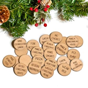 Puede incluir: Un conjunto de 16 fichas de actividades navide&ntilde;as de madera con varias actividades tem&aacute;ticas de las fiestas escritas en ellas, como "Hacer una casa de jengibre", "Leer un libro de Navidad", "Hacer una donaci&oacute;n", "Ir a ver las luces de Navidad", "Ver una pel&iacute;cula de Navidad", "Hacer malvaviscos", "Chocolate caliente y malvaviscos", "Hacer comida para renos", "Hornear galletas para Santa", "D&iacute;a de pijama", "Vestir de rojo", "M&aacute;s decoraciones para el &aacute;rbol", "Noche de juegos", "Actividades divertidas", "Hacer una manualidad navide&ntilde;a", "Sin tareas", y "Hacer una lista de gratitud".