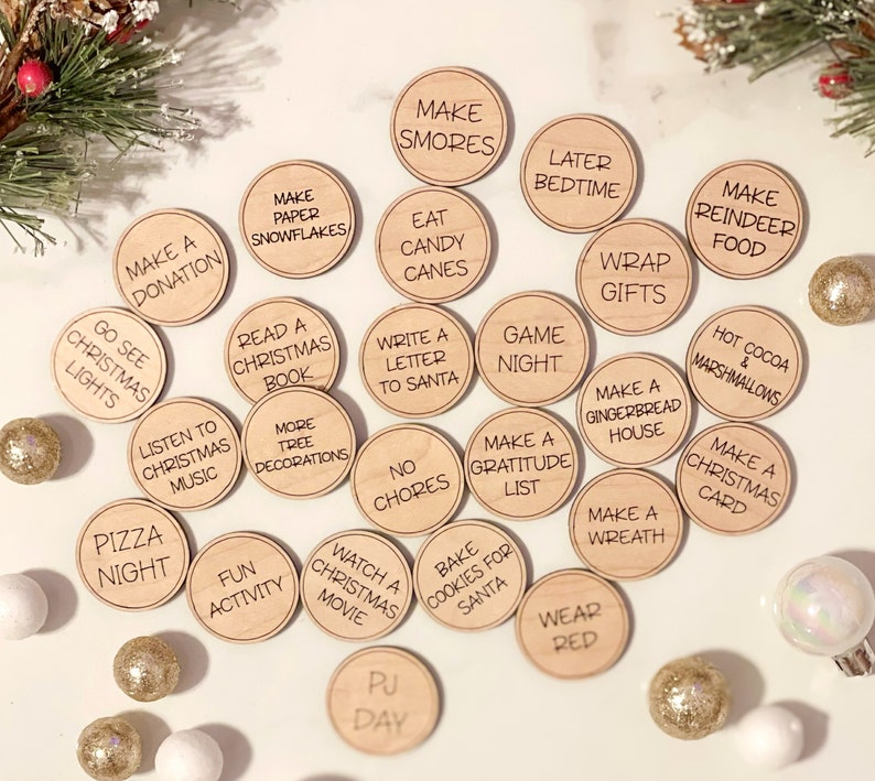 Puede incluir: Un conjunto de 20 c&iacute;rculos de madera para actividades navide&ntilde;as con diversas actividades festivas escritas en ellos, como "Hacer Smores", "Ir a ver las luces de Navidad", "Leer un libro de Navidad", "Hacer una casa de jengibre", "Hornear galletas para Santa", "Ver una pel&iacute;cula navide&ntilde;a", "Vestir de rojo", "Hacer una tarjeta navide&ntilde;a", "Hacer una corona", "Hacer una lista de gratitud", "Noche de juegos", "Escribir una carta a Santa", "Sin tareas", "Actividad divertida", "D&iacute;a de pijama", "Hacer comida para renos", "Chocolate caliente y malvaviscos", "Comer bastones de caramelo", "Hacer copos de nieve de papel", "Acostarse tarde", "Envolver regalos", "Hacer una donaci&oacute;n".