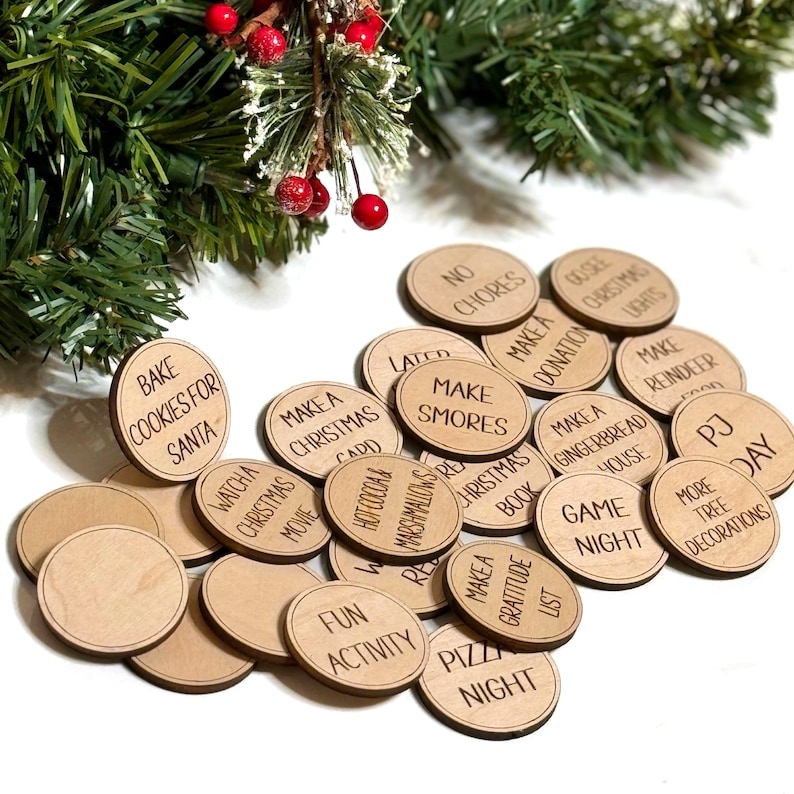 Puede incluir: Un conjunto de 20 fichas de actividades navide&ntilde;as de madera con varias actividades tem&aacute;ticas navide&ntilde;as escritas en ellas, como "Hornear galletas para Santa", "Hacer Smores", "Noche de juegos" y "D&iacute;a de pijama".