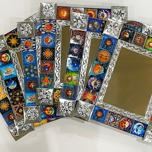Peut inclure: Ensemble de quatre miroirs encadrés argentés avec des motifs colorés de soleil et de lune. Chaque cadre est décoré d'un motif floral.