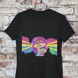 May include: Black t-shirt featuring a colourful graphic of a mushroom with a face and a psychedelic background.