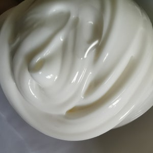May include: Close-up of white slime with a smooth, glossy texture. The slime is being stretched and folded, creating swirls and peaks.