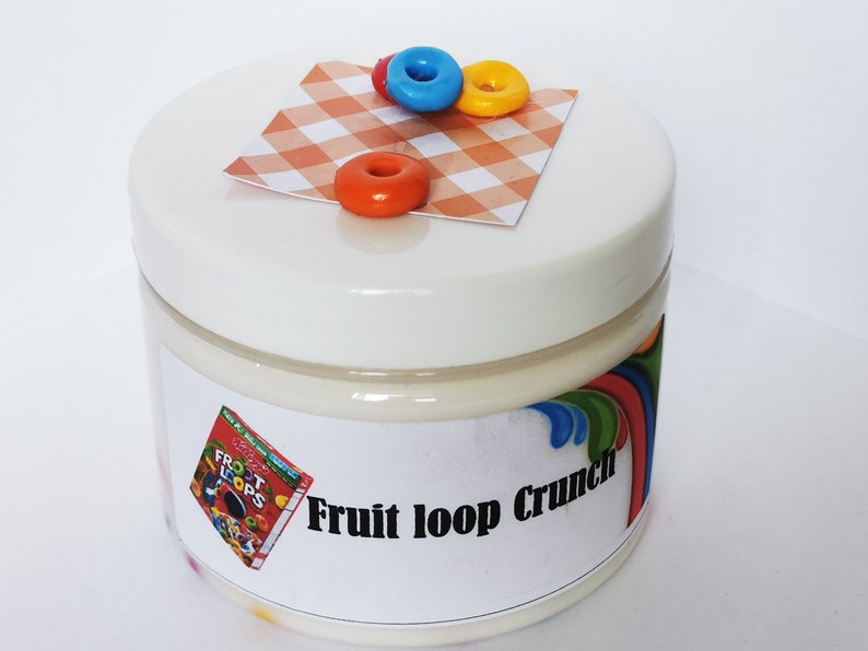 May include: A white jar with a white lid and a label that says "Fruit Loop Crunch". The jar is decorated with a red, yellow, and blue cereal loop on a checkered red and white background.