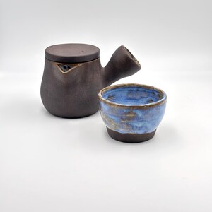 Può includere: Un set di tre tazze in ceramica con finitura opaca e macchiettata. Le tazze sono nei toni del crema, grigio chiaro e grigio scuro. Ogni tazza ha un design semplice e minimalista e un manico arrotondato.
