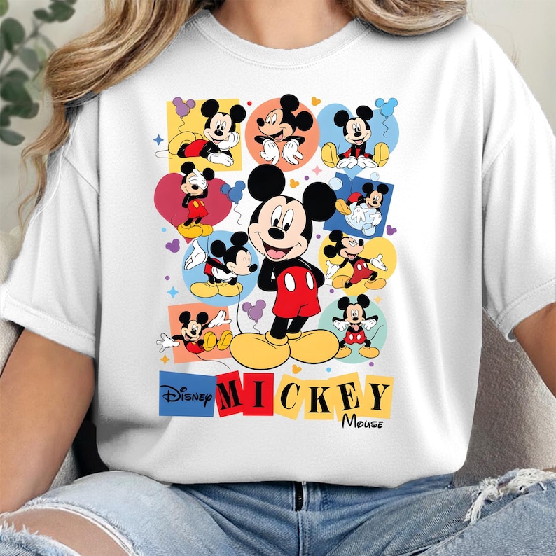 Pu&ograve; includere: T-shirt bianca con una grafica colorata di Mickey Mouse. Il design include pi&ugrave; immagini di Mickey in varie pose, su sfondi colorati. I loghi Disney e Mickey Mouse sono visualizzati in basso.