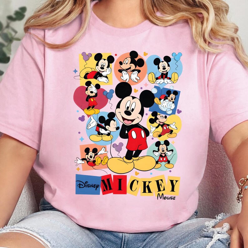 Pu&ograve; includere: Una maglietta rosa chiaro con una grafica colorata di Topolino in varie pose. Il design include i loghi Disney e Topolino. Il personaggio dei cartoni animati &egrave; raffigurato con i suoi classici pantaloncini rossi, scarpe gialle e guanti neri.