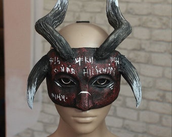 Handmade mask on the floor of the face is a demon with horns druid