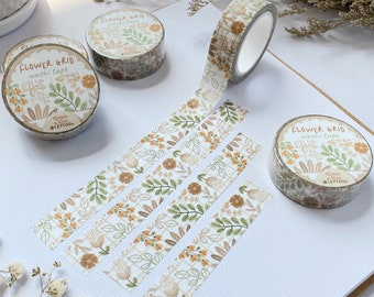 May include: Four rolls of floral patterned washi tape with a grid design. The tape is 15mm wide and 10 meters long. The tape is labeled "FLOWER GRID washi tape" and "@LETTOO".