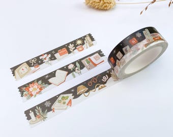 May include: A roll of decorative washi tape featuring a dark background with illustrations of books, reading glasses, candles, poinsettias, and snowflakes. The tape is unrolled to show repeating patterns of literary and seasonal motifs in warm tones.