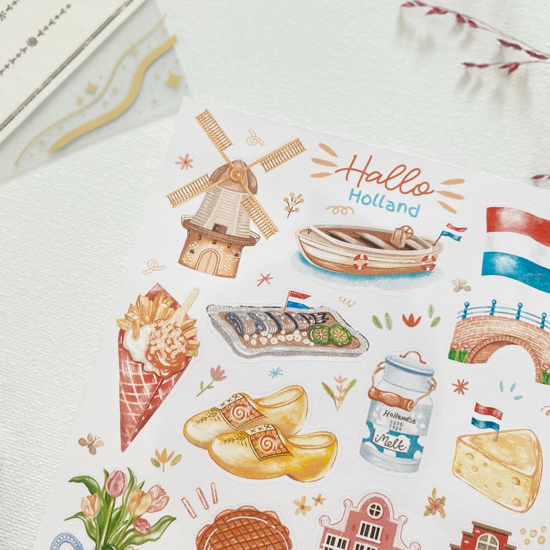 May include: A set of colorful stickers featuring Dutch icons like windmills, clogs, tulips, and a canal boat. The stickers also include a Dutch flag, a brick bridge, and a container of milk with the text "Hollandse Melk".