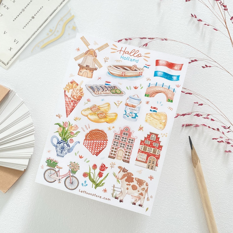May include: A set of colorful stickers featuring Dutch icons like windmills, clogs, tulips, and houses. The stickers also include a boat, cheese, milk, and a cow. The text "Hallo Holland" is written in a whimsical font.