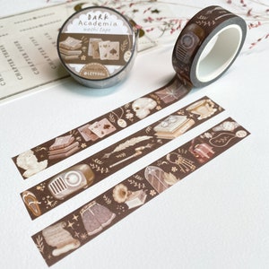 Peut inclure: Trois rouleaux de ruban adh&eacute;sif washi brun avec des illustrations de livres, de cl&eacute;s, d'un cr&acirc;ne, d'un gramophone, d'une plume et d'une horloge. Le ruban est &eacute;tiquet&eacute; "DARK Academia washi tape" et "15mm x 10m @LETTOON".