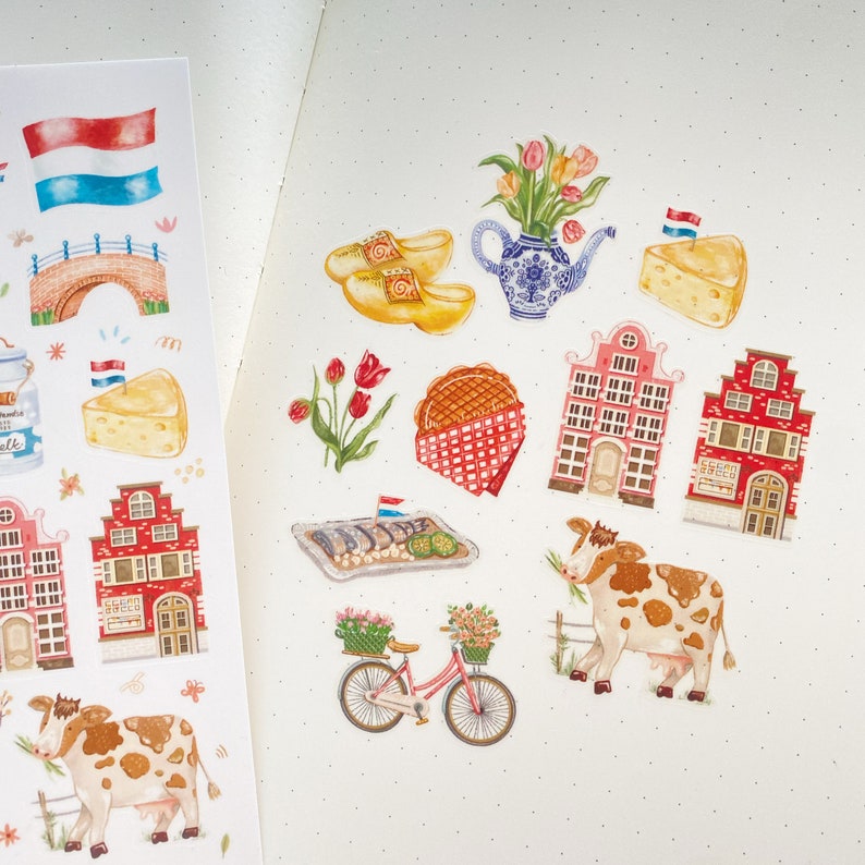 May include: A set of colorful stickers featuring Dutch themes, including houses, clogs, windmills, and a cow. The stickers are perfect for adding a touch of Dutch charm to your planner, journal, or scrapbook.
