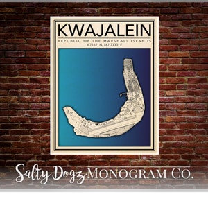 Puede incluir: Una impresión de mapa de estilo vintage de Kwajalein, República de las Islas Marshall, con un esquema de color azul y turquesa. El mapa muestra el contorno de la isla y sus características, incluida una pista de aterrizaje. La impresión tiene un borde blanco y el texto "Salty Dogz MONOGRAM CO." en la parte inferior.
