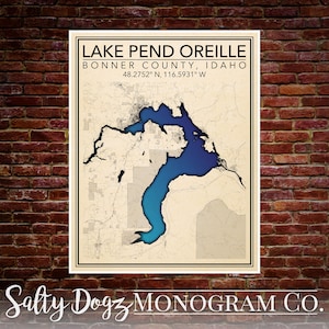 May include: A vintage-style map print of Lake Pend Oreille in Bonner County, Idaho. The lake is highlighted in blue and the surrounding area is in beige. The coordinates 48.2752° N, 116.5931° W are printed below the lake name. The text "Salty Dogz MONOGRAM CO." is printed at the bottom of the print.