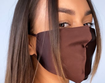 May include: A brown satin face mask with a smooth, silky texture. The mask covers the nose and mouth and has adjustable ear loops.