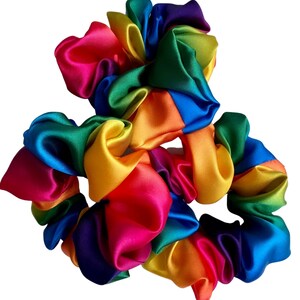 May include: Three rainbow-colored satin scrunchies. The scrunchies are made of a soft, silky fabric and are perfect for adding a pop of color to any outfit.