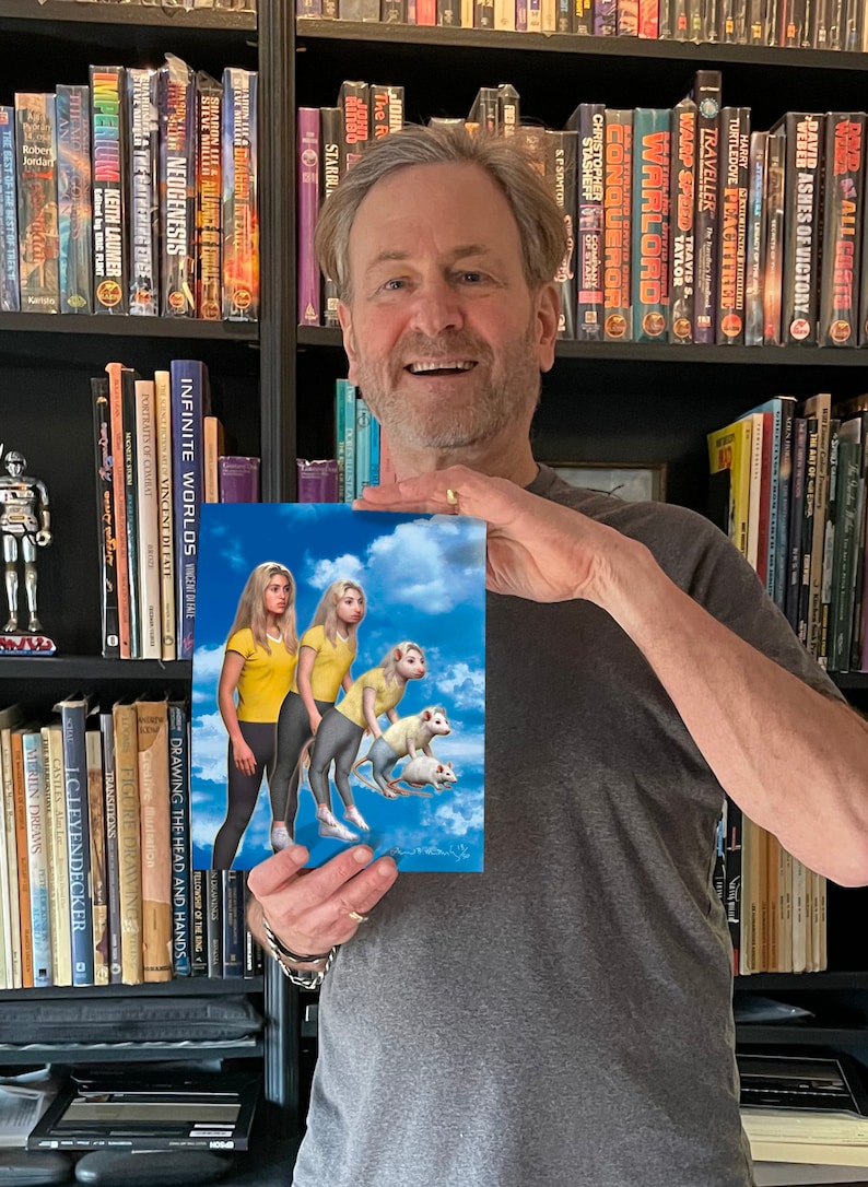 May include: A man is holding a book cover featuring two women and three white rats in a blue sky with white clouds. The book cover has the title "Infinite Worlds" and the author's name "Vincent Di Fave".