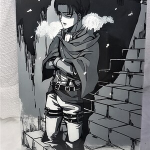 K&ouml;nnte beinhalten: Eine Schwarzwei&szlig;illustration eines Charakters aus dem Anime Attack on Titan. Der Charakter steht auf einer Treppe und tr&auml;gt einen Umhang. Der Hintergrund ist eine Schneelandschaft.