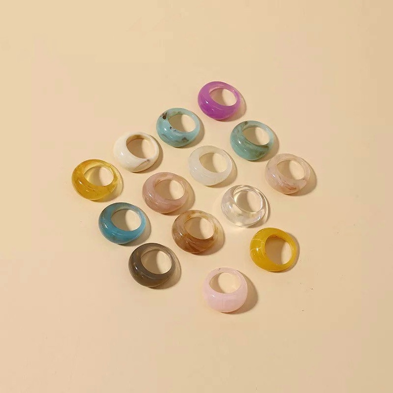 collection of Retro Colourful Resin Rings in multiple colours on yellow background