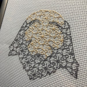 May include: A white fabric with a gold and grey embroidered design. The design is a circular shape with a floral pattern.