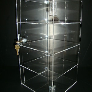 May include: A clear acrylic display case with a lock and key. The case has four shelves and is ideal for displaying small items.