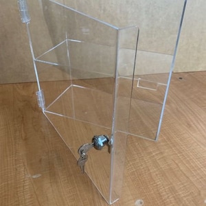 May include: A clear acrylic display case with a lock and key. The case has two shelves and is made of sturdy acrylic.