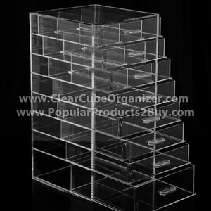 K&ouml;nnte beinhalten: Klarer Acryl-Organizer mit mehreren Schubladen. Der Organizer ist aus klarem Acryl gefertigt und hat ein elegantes, modernes Design. Er ist perfekt zum Aufbewahren und Organisieren von kleinen Gegenst&auml;nden wie Schmuck, Make-up oder B&uuml;robedarf.