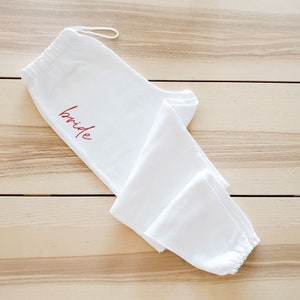 May include: White sweatpants with a red "bride" inscription.