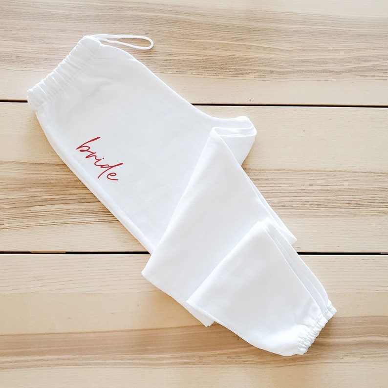 May include: White sweatpants with a red "bride" inscription.