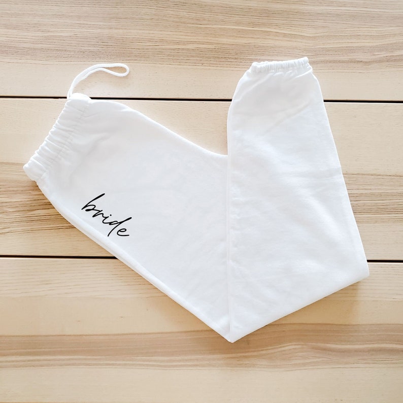 May include: White sweatpants with a black "bride" inscription.