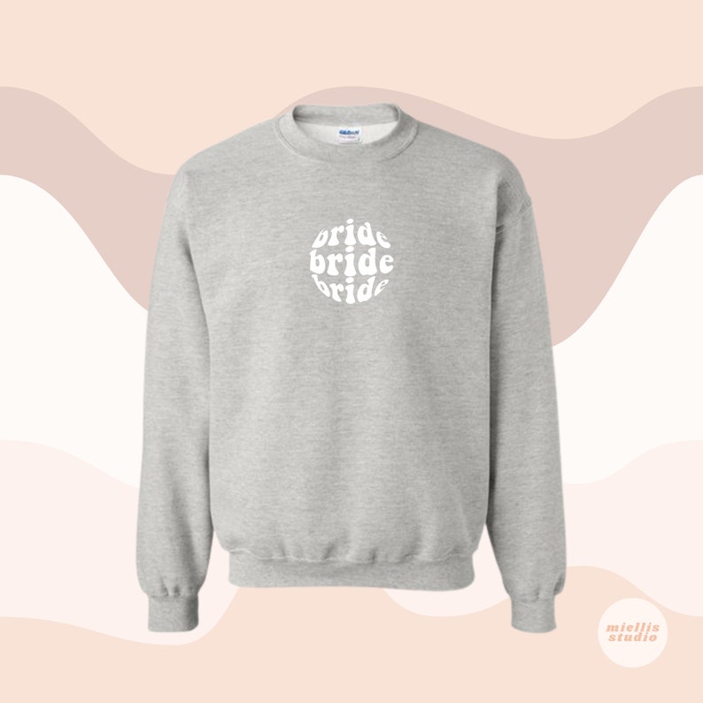 May include: A gray sweatshirt with a white circle design that says "bride" three times in a retro font.