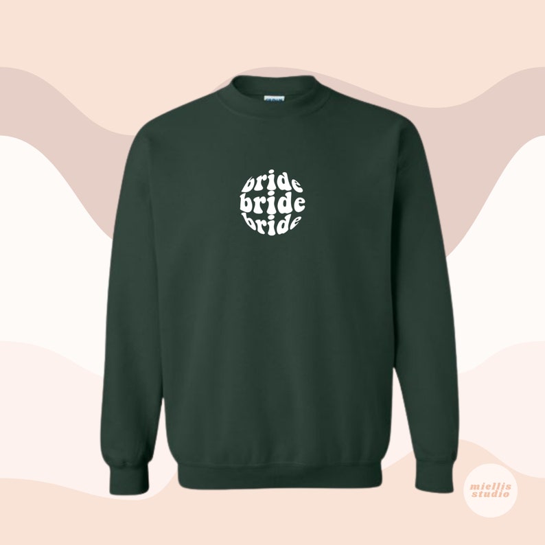 May include: A dark green sweatshirt with a white circle graphic that says "bride bride bride" in a retro font.