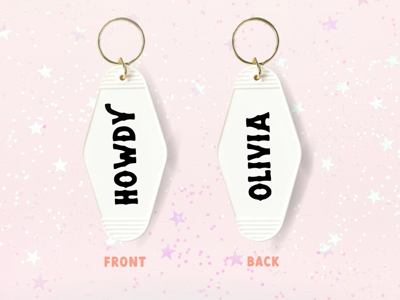 May include: White motel key chain with a gold ring. The front side says "HOWDY" in black lettering. The back side says "OLIVIA" in black lettering.