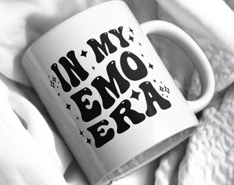 May include: White ceramic mug with a black graphic that says "In My Emo Era" with stars around the text.