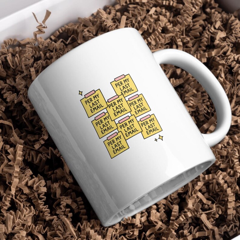 May include: White ceramic mug with the text "PER MY LAST EMAIL" printed on yellow sticky notes. The mug is inside a white box filled with brown paper shreds. The mug has a white handle and a simple design.
