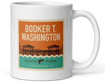 Puede incluir: Taza de cerámica blanca con un diseño retro para el Parque Estatal Booker T. Washington, Chattanooga, TN. El diseño incluye texto, una ilustración de muelle y un gráfico de pez. La taza tiene un asa curva.
