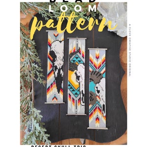 May include: Three beaded bracelets featuring a desert skull design. The bracelets are crafted with white, grey, orange, yellow, blue, and turquoise beads. The bracelets are displayed on a dark wooden surface. The text "DESERT SKULL TRIO BRACELET PATTERN clovecreativestudio.etsy.com" is positioned below the bracelets.