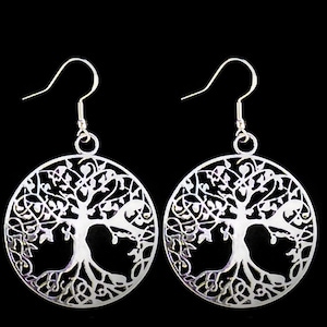 May include: Silver earrings with a tree of life design. The earrings are circular and feature a detailed cutout of a tree with branches and roots.