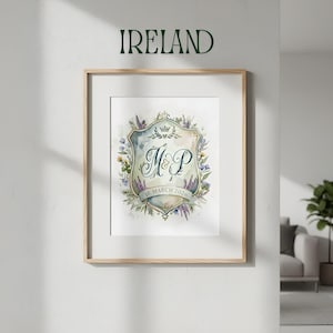 May include: A framed watercolour print with a crest design, the initials "M&P", and the date "18 March 2026". The crest is surrounded by blue, purple, and yellow floral elements. The word "IRELAND" is above the frame, in green letters.